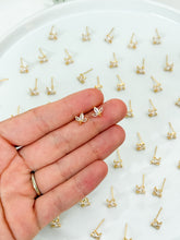 Load image into Gallery viewer, Gold earrings displayed on a hand with a white background
